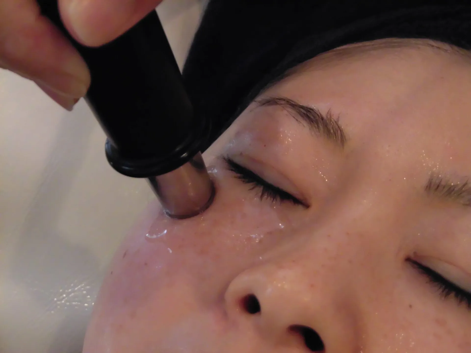 フェイシャルサロンで目元にソニックエステを受けている女性